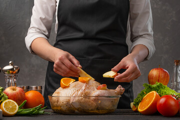 Decoration of a festive chicken by a chef with apples. Family dinner, homemade recipe for the hostess. Restaurant business and menu