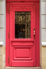 Obraz premium Beautiful front door in an old city. Elegant wooden door of red color.