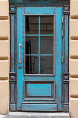 Obraz premium Beautiful front door in an old city. Elegant wooden door of blue color.