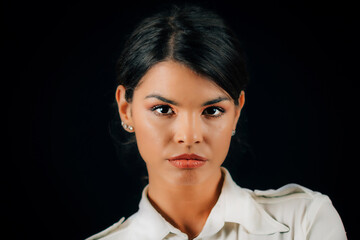 Emotion Jealousy. Portrait of a beautiful jealous young woman, studio portrait, black background