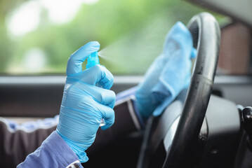 Driver handles car steering wheel with antiseptic close up.