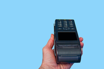 Hand is holding a credit card payment terminal on blue background.