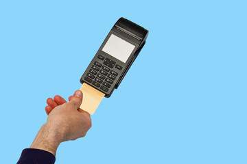 The hand holds a credit card on the payment terminal. Isolated on blue background