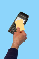 The hand holds a credit card on the payment terminal. Isolated on blue background