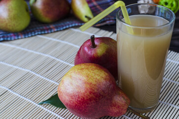 a glass of pear juice and bright red pears on a light background healthy food