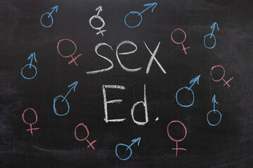 Concept of sex education on the blackboard, female and male sign.