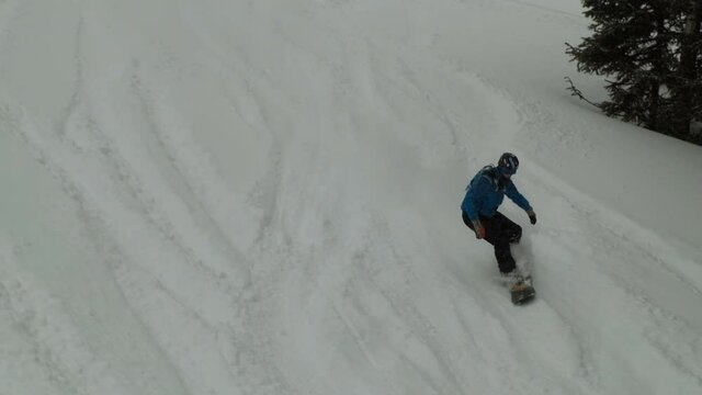 Top view of a man riding a snowboard on a powder.