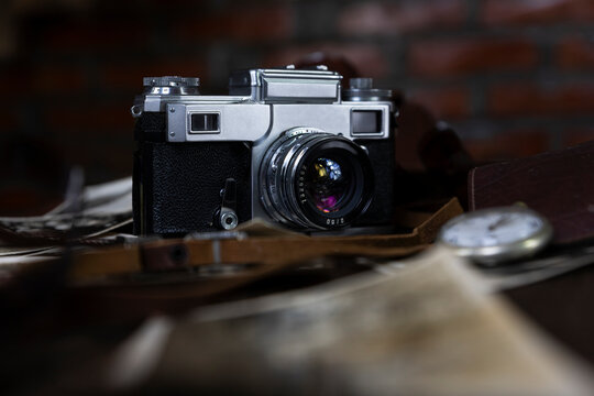 Vintage film camera and old photographs on a rustic surface