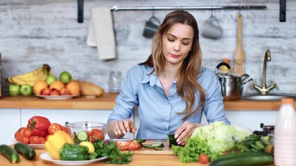 Casual housewife cutting cucumber on wooden board feeling headache. Medium shot on RED camera