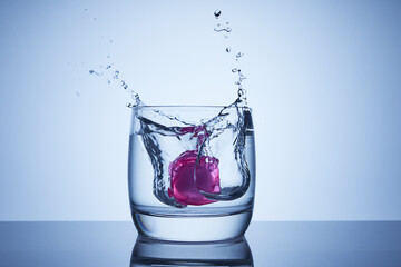 Reusable cooling cubes falls into a glass of water or alcohol with splashes and drops. Insulated...