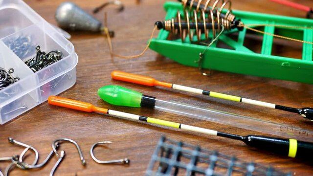 Fishhooks, lines, sinkers, floats and tackle boxes. Fishing equipment on brown wooden table background. Sport and recreation concept