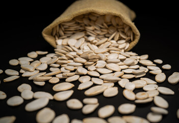 Dried pumpkin seeds from a sac on a table