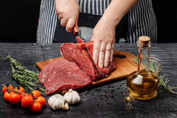 A woman slices a piece of meat into steaks.