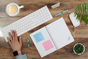 Top view on a desk with keyboard, notepad and computer mouse. Business flat lay on wooden background