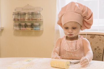 Little girl cooks at home in the kitchen