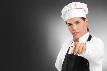 Transgender chef pointing at viewer on dark background