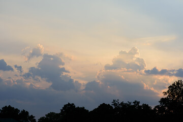 Beautiful vanilla sky with clouds before sunset above the trees