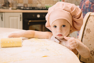 Little girl cooks at home in the kitchen