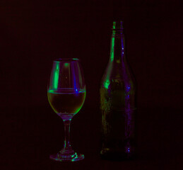 
glass with bottle of wine in the dark