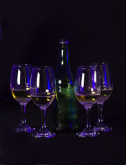 glasses in the dark with bottle of wine in the middle