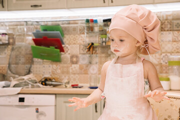 Little girl cooks at home in the kitchen