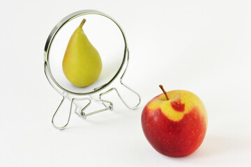 Red apple looking in the mirror and seeing itself as a pear - Concept of dysmorphobia and distorted...