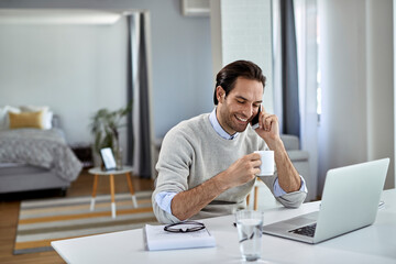 Happy entrepreneur talking on the phone while working at home.