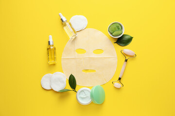 Composition with fabric facial mask, cosmetics and cucumber on color background