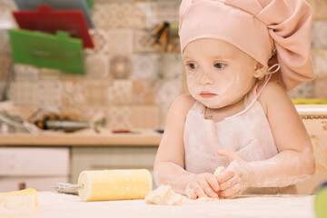 Obraz na płótnie Canvas Little girl cooks at home in the kitchen
