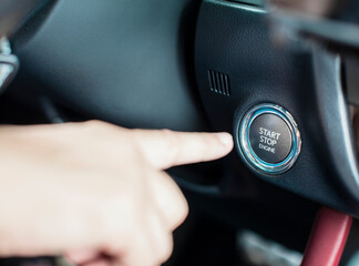  finger and Engine start stop button in the car