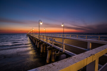 Fototapeta na wymiar Amazing sunrise over the pier at baltic sea. Summer background