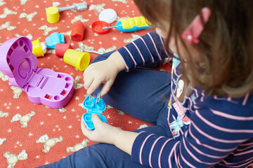 little girl playing with dentist tools toys