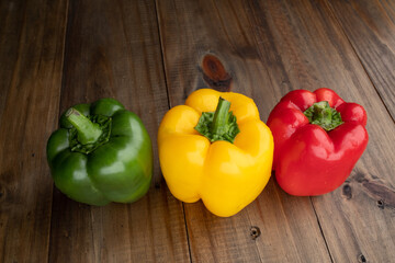 sweet pepper on wood background, paprika, red, green and yellow sweet bell peppers on table
