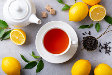 Tea cup and pot with lemon. Grey background. Close up. Top view.