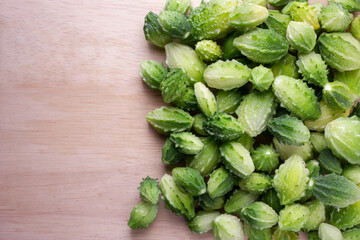Fresh bitter gourd, balsam apple,   bitter melon or Momordica charantia on wooden background.