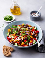Lentil salad with mix vegetables in bowl. Grey background.