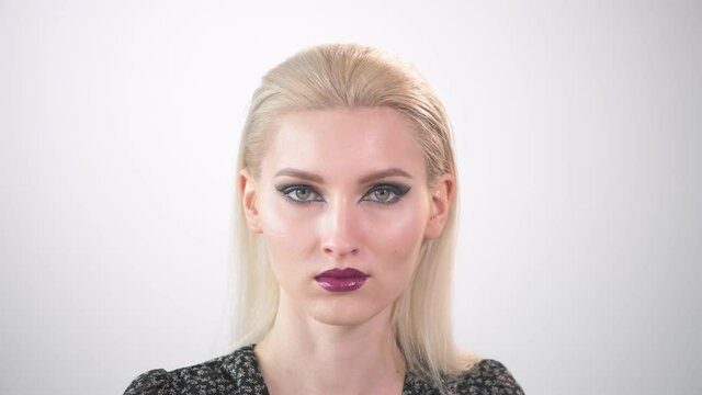 Beautiful young blonde with bright makeup. with purple lipstick.