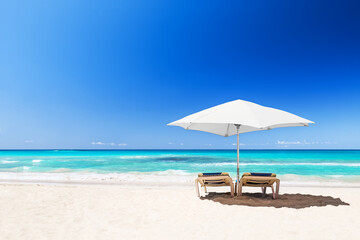 Beach chairs with umbrella and beautiful sand beach in Punta Cana, Dominican Republic