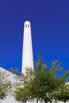Bright white Msheireb Mosque Minaret against blue sky on a sunny day