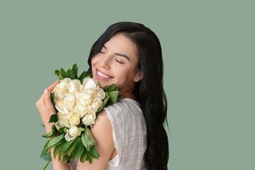 Beautiful young woman with bouquet of roses on color background