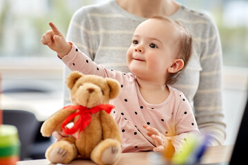 remote job, multi-tasking and family concept - close up of happy baby with mother working at home office