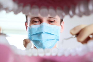 The dentist looks at the layout of the oral cavity and holds dental instruments for examination....