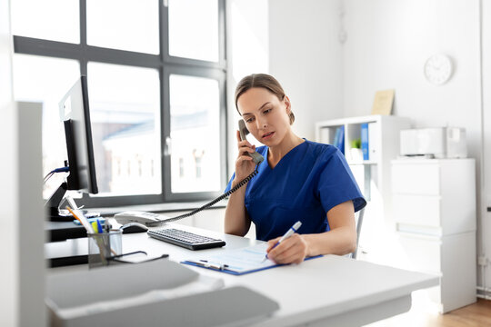 medicine, technology and healthcare concept - female doctor or nurse with computer and clipboard calling on phone at hospital
