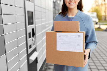 mail delivery and post service concept - close up of happy smiling woman with boxes at outdoor...