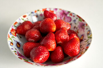 strawberries lie in a plate on the kitchen table