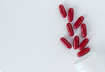 Red pills and capsules in a plastic bottle on a white background for use in presentations, manuals, design, etc. 3D illustration. Medicine concept. top view