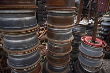 Used rims at columns, in a nice order. Awaiting recycling or re-sale. At a car cemetery, Kozani, Greece.