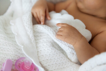 Obraz na płótnie Canvas Newborn baby sleeping covered in white blanket in a selective focus