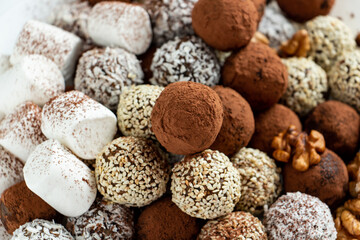 a lot of delicious chocolate truffles, rolled in cocoa, coconut, sesame with marshmallows and nuts, delicious and beautiful dessert