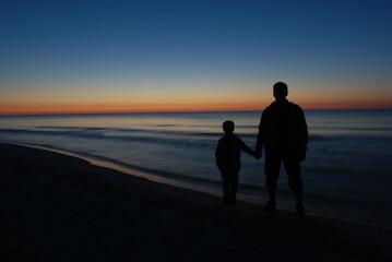 child with a parent on the beach